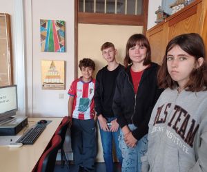 Dwie dziewczynki i dwóch chłopców wygłaszają swoją prezentację na lekcji języka angielskiego