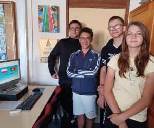 Dziewczynka i trzech chłopców wygłaszają prezentację na języku angielskim