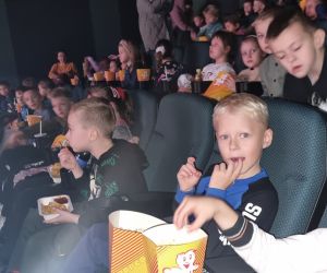 Uczniowie w Sali kinowej oglądają bajkę