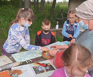 Dzieci przy stole podczas warsztatów garncarskich