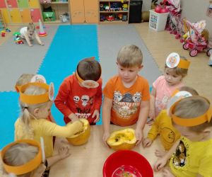 Przedszkolaki sprawdzają wnętrze dyni i smakują jej nasionka.