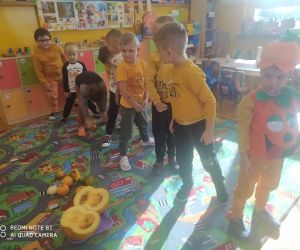 dzieci podają sobie dynię w pozycji stojącej