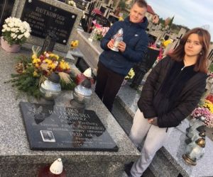 Uczennica i uczeń przy grobie bohatera walk o niepodległość na cmentarzu w Czerniczynie