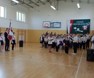 Poczet sztandarowy oraz uczniowie szkoły na tle dekoracji