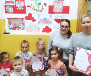 Nauczycielki z uczestnikami konkursu na tle konkursowych prac