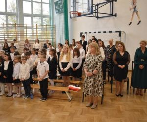 Uczniowie i nauczyciele stoją podczas Mszy św.