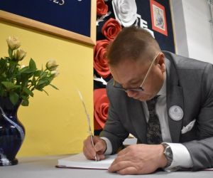 Pan Sekretarz dokonuje wpisu w księdze pamiątkowej