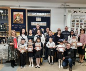 Dyrektor, wychowawczyni, rodzice i pierwszoklasiści na wspólnym zdjęciu