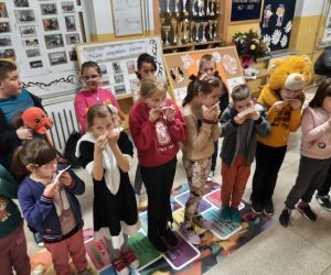 grupa uczniów zajada miód