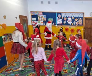 Dzieci tańczą z Mikołajem i jego pomocnicami.