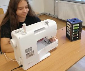 Dziewczynka szyje na maszynie do szycia