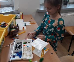 Dziewczynka  buduje klockami lego