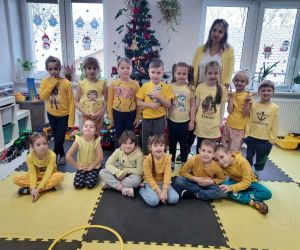 Dzieci z oddziału przedszkolnego z wychowawczynią w żółtych ubraniach