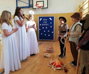 Trzy uczennice w strojach aniołków stoją przed trzema uczniami przebranymi za pastuszków