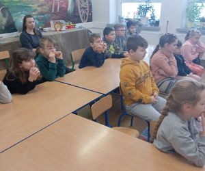 Uczniowie i nauczycielka słuchają opowieści