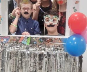 Nauczyciel z uczniami w fotobudce