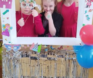 Trzy dziewczynki z klas młodszych w fotobudce