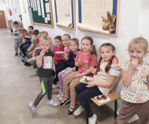Dzieci ze starszej grupy przedszkolnej jedzą pączki i gofry