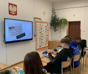 Uczniowie przepisują tekst z tablicy multimedialnej