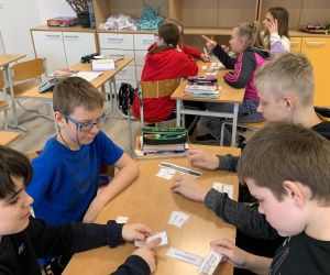 Uczniowie klasy piątej układający karteczki z zagadką językową