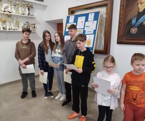 Uczniowie czytający łamańce językowe na głównym korytarzu szkoły