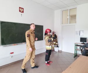 Uczeń prezentuje strój strażaka