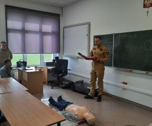 Strażak omawia zasadę działania defibrylatora AED