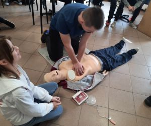 Uczniowie podłączają defibrylator