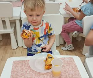 Dzieci konsumują pyszną pizzę.