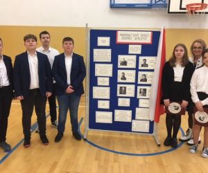 Uczniowie klasy VII z wychowawcą stoją na tle dekoracji