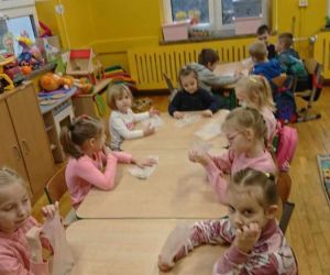 Dzieci własnoręcznie nawlekają koraliki.