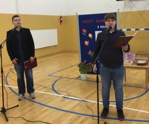 Dwóch starszych chłopców stoi przy mikrofonach