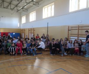 Chłopiec częstuje dziewczynki słodkim batonikiem z okazji ich święta,