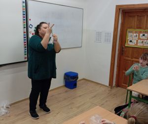 Prowadząca warsztaty prezentuje kolejne czynności wykonania breloczków