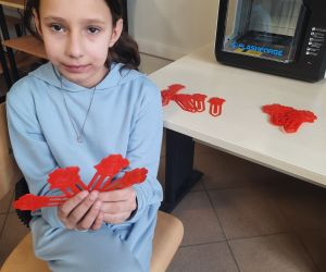 Dziewczynka trzyma wydrukowane zakładki do książek