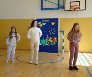 Trzy dziewczynki tańczą na tle dekoracji wiosennej