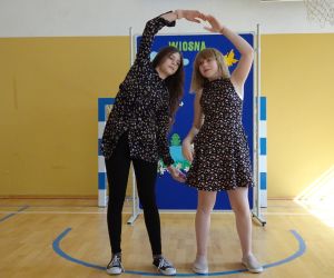 Dwie dziewczynki tańczą na tle dekoracji wiosennej