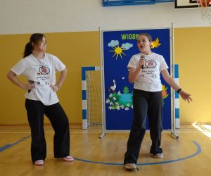 Dwie starsze dziewczynki tańczą na tle dekoracji wiosennej