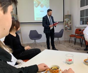 Nauczyciel prowadzący spotkanie na tle ekranu z prezentacją