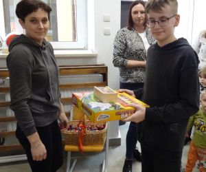 Mama z Rady Rodziców wręcza nagrodę uczniowi klasy czwartej