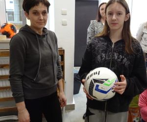 Mama z Rady Rodziców wręcza nagrodę uczennicy klasy szóstej