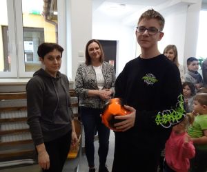 Mama z Rady Rodziców wręcza nagrodę uczniowi klasy ósmej