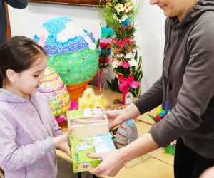 Mama z Rady Rodziców wręcza nagrodę uczennicy klasy pierwszej