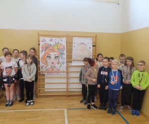 Konkurs Pani Wiosna uczniowie klasy czwartej i drugiej na tle swoich prac