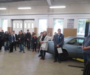 Uczniowie z opiekunami w warsztacie naprawy aut