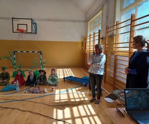 Wychowawczyni klasy pierwszej przy mikrofonie ogłasza wyniki konkursu na najpiękniejszą zakładkę  do książki