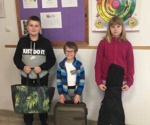 Uczniowie klasy czwartej z zastępnikami plecaków