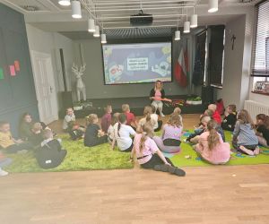 Pani instruktor tłumaczy dzieciom zasady używania Bum Bum Rurki