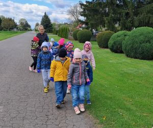 Dzieci zbierają śmieci wokół przedszkola.