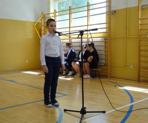 Uczeń klasy trzeciej recytuje przy mikrofonie